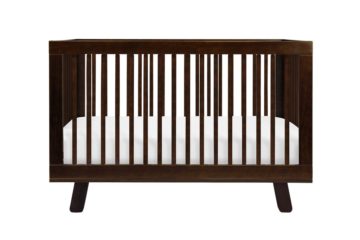 Brown wooden crib with white mattress.