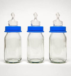 Three glass baby bottles with blue caps.
