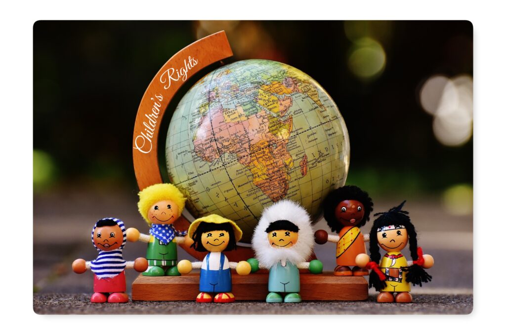 Wooden dolls stand by a globe, children's rights.