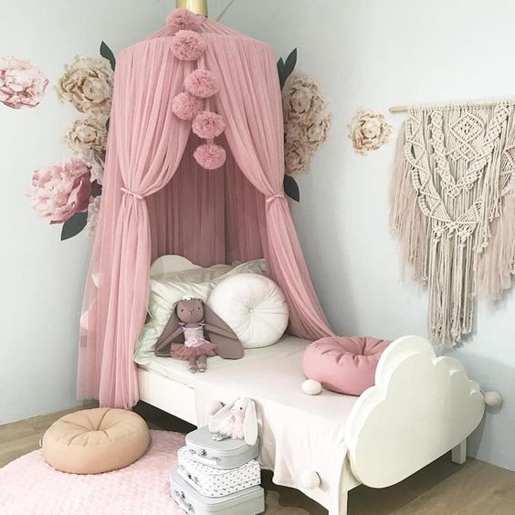 Pink canopy bed with stuffed animal.