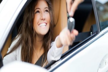 Smiling woman receives car keys.