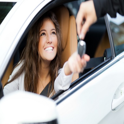 Smiling woman receives car keys.