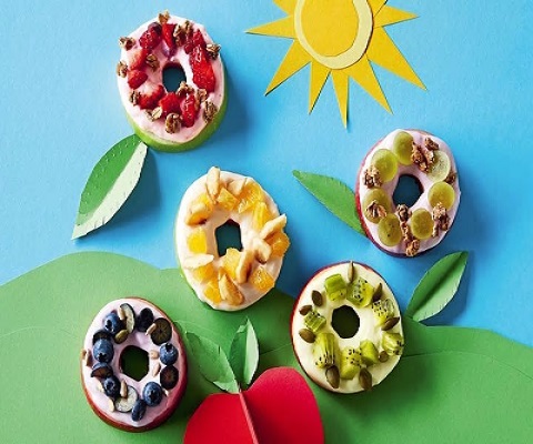 Fruit-topped apple donuts on a blue background.