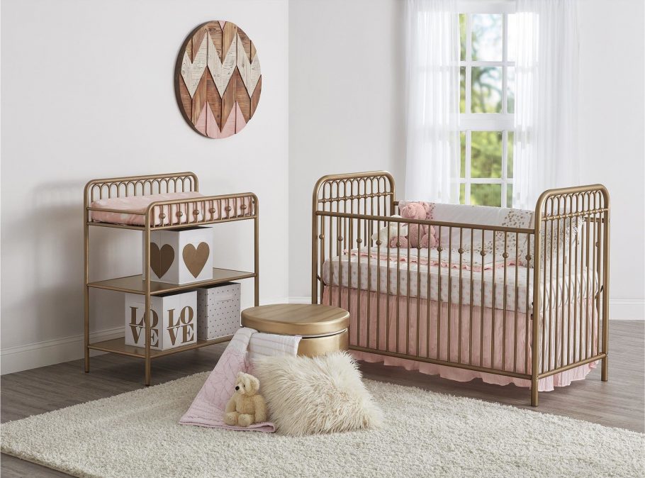 Gold crib and changing table in nursery.