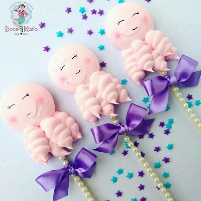 Pink meringue pops with purple bows and pearl sticks.