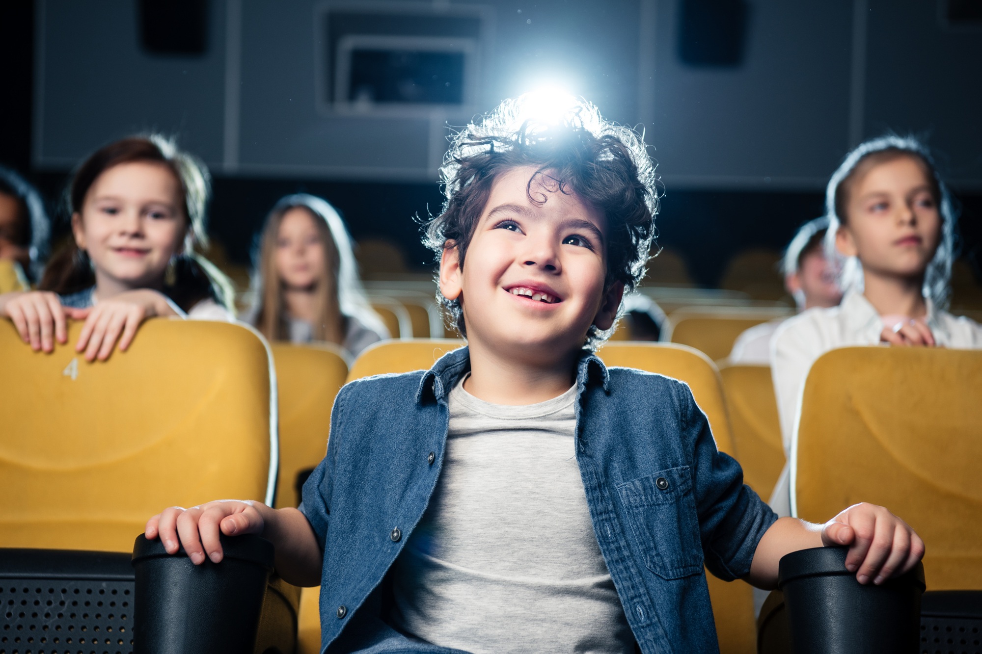 Children sitting together watching a movie in a cinema